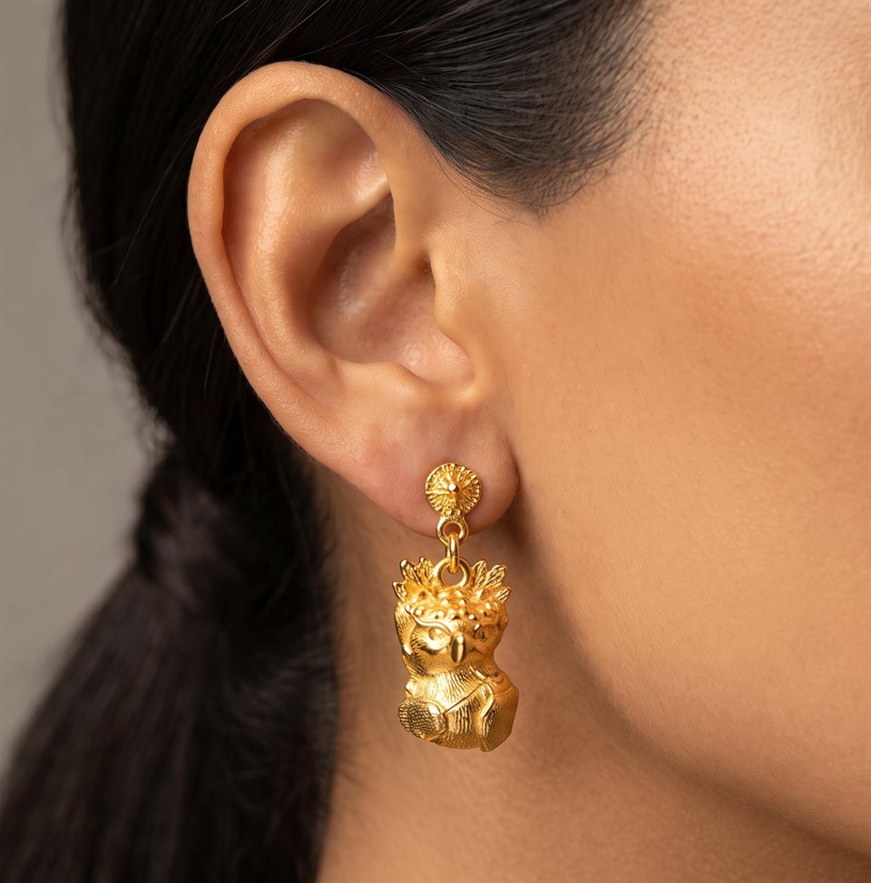 Textured gold harpy eagle drop earring, close-up worn