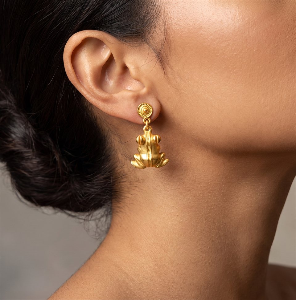 Gold frog drop earring, close-up worn