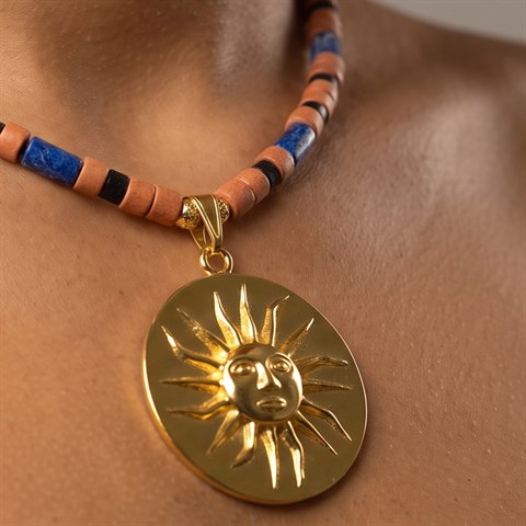 Model wearing a gold sun medallion necklace, symbol of Colombia's Zenú and Tairona