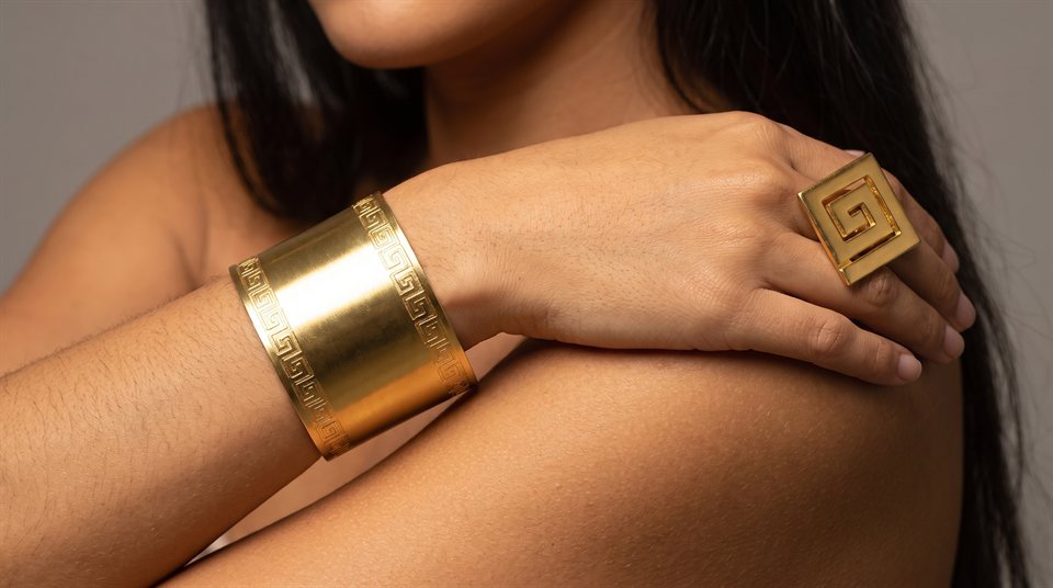 Wide gold cuff with pre-Columbian engraving, worn with a matching square ring