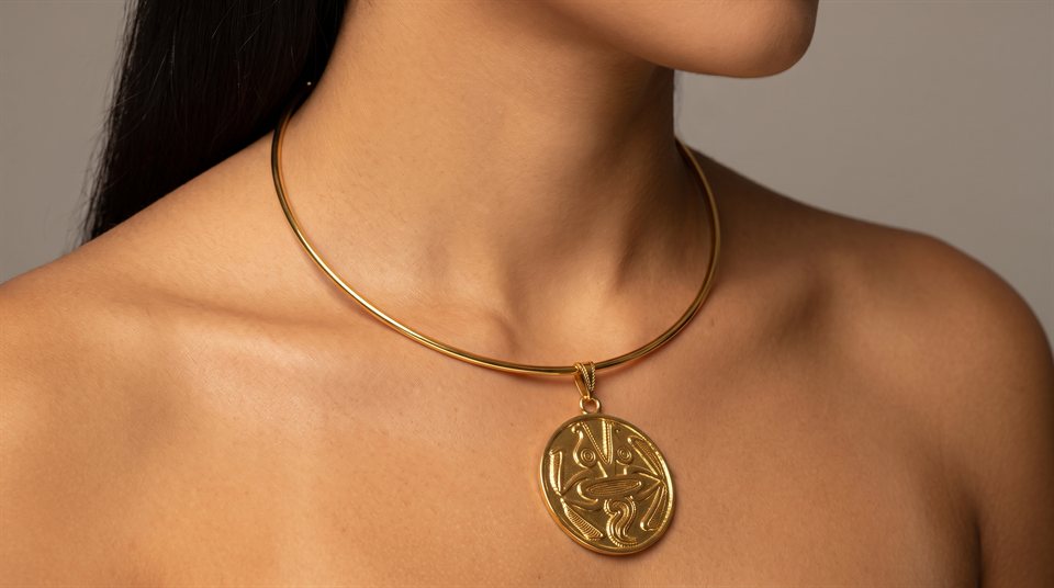 Model wearing a rigid gold wire collar with an engraved gold medallion