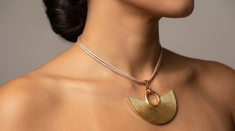 Model wearing a slim cord necklace with a smooth-filigree nariguera in gold