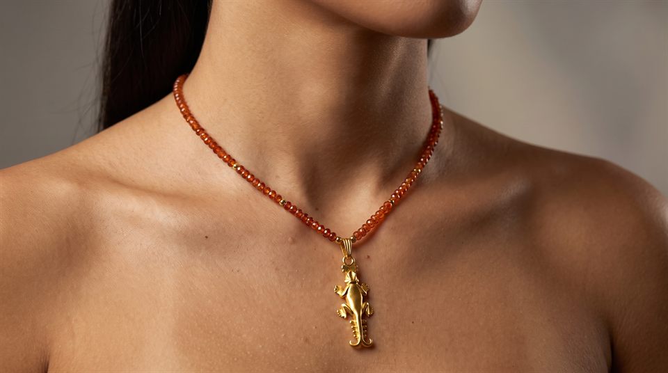 Hessonite garnet bead necklace with a gold lizard pendant