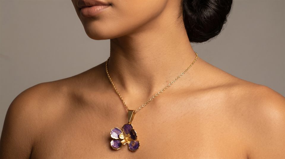 Fine gold chain with a purple enamelled orchid pendant, worn