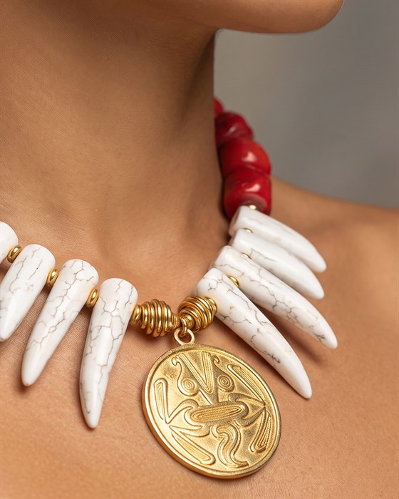 Red coral and white howlite necklace with an engraved gold Gran Coclé medallion, worn