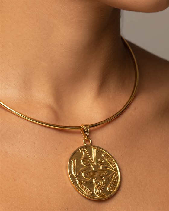 Rigid gold collar with a frog medallion, worn