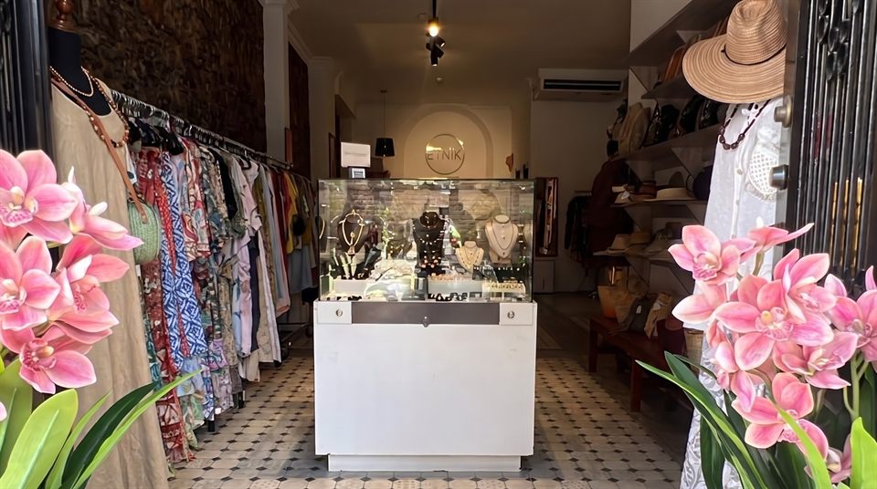 Entrance of the Etnik boutique in Casco Antiguo, framed by pink orchids
